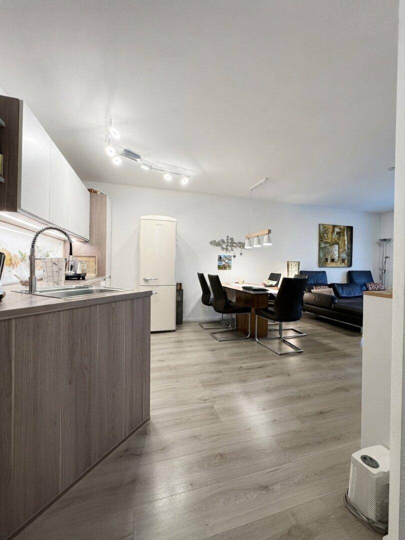 Offener Wohnbereich mit integrierter Küche, Esstisch und Blick auf das Wohnzimmer.