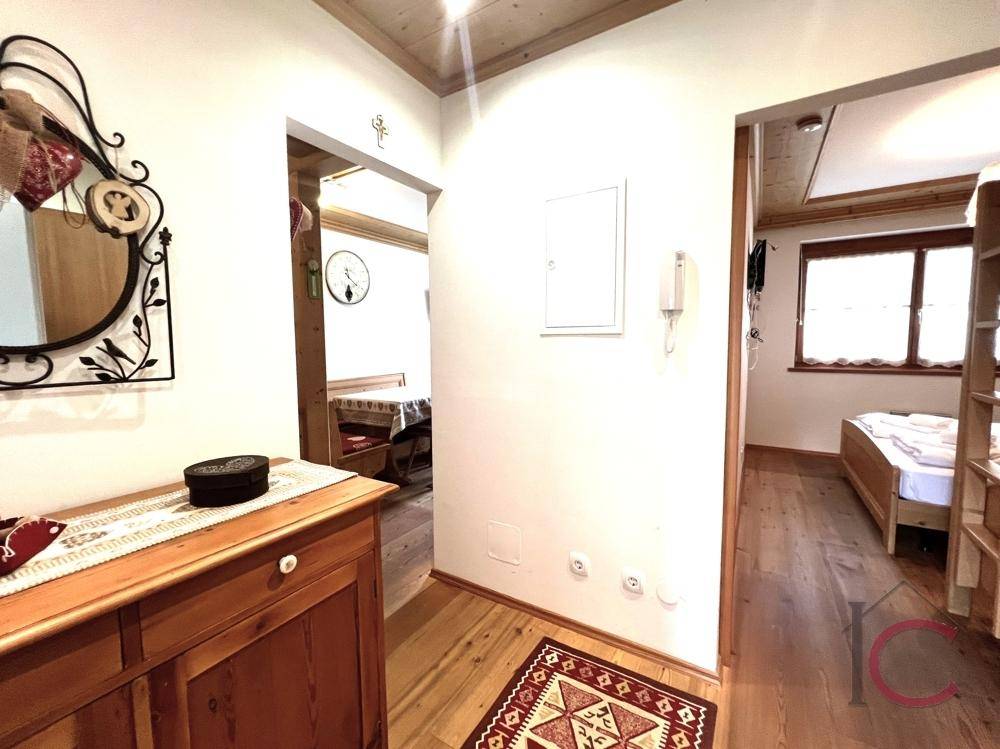 Gemütlicher Flur mit Holzmöbeln und traditionellem Teppich, der zu den angrenzenden Räumen führt.
