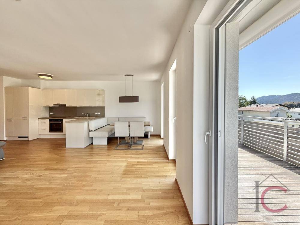 Moderner Wohnbereich mit offener Küche, Essplatz und direktem Zugang zur sonnigen Terrasse.