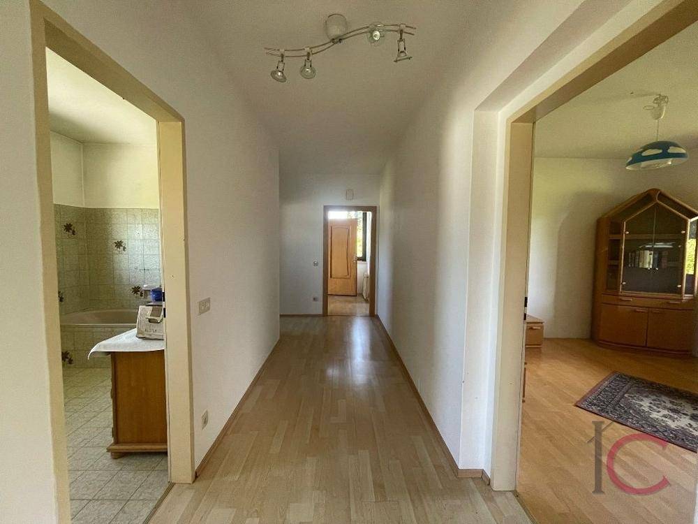 Heller Flur mit Laminatboden und Zugängen zu Badezimmer und weiteren Wohnräumen.