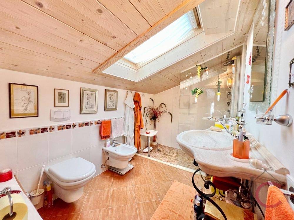 Helles Badezimmer im Dachgeschoss mit Dusche, Bidet und Dachfenster.