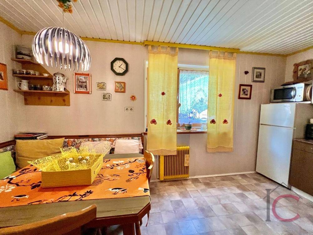 Helle Küche mit Essbereich, Fenster und einfacher Ausstattung, ideal für den täglichen Gebrauch.