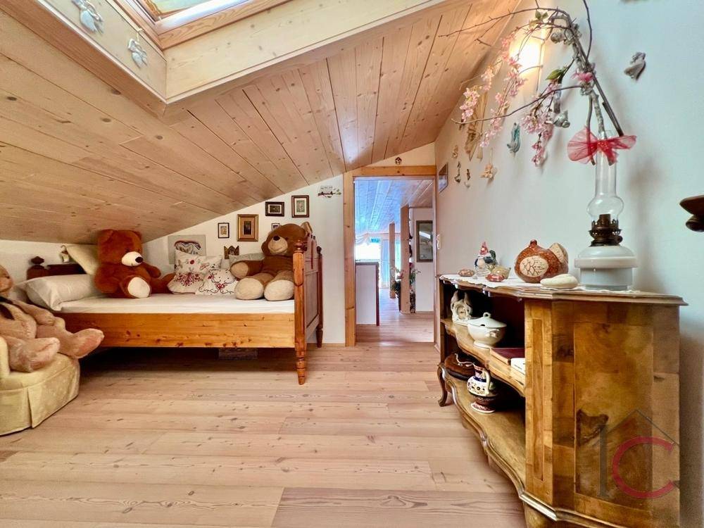 Kinderzimmer im Dachgeschoss mit Holzboden, Dachfenster und Spielzeug.