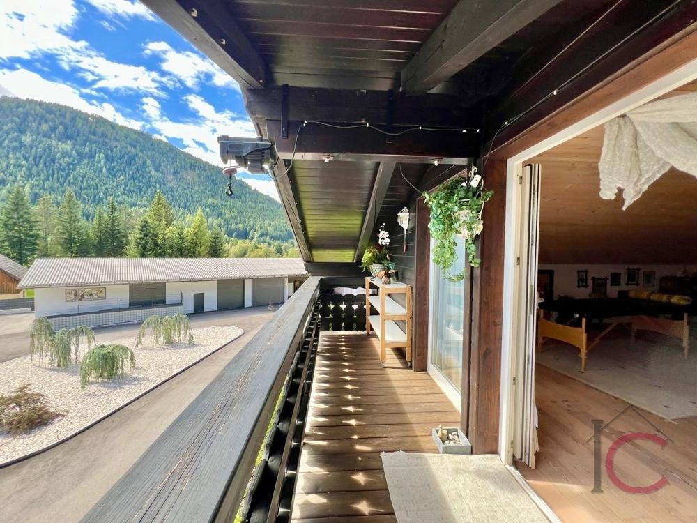 Geräumiger Balkon mit Holzboden und beeindruckendem Bergblick.