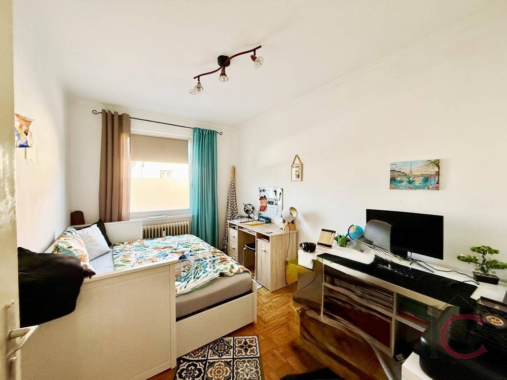 Kinder- oder Gästezimmer mit Einzelbett, Schreibtisch und Blick nach draußen.