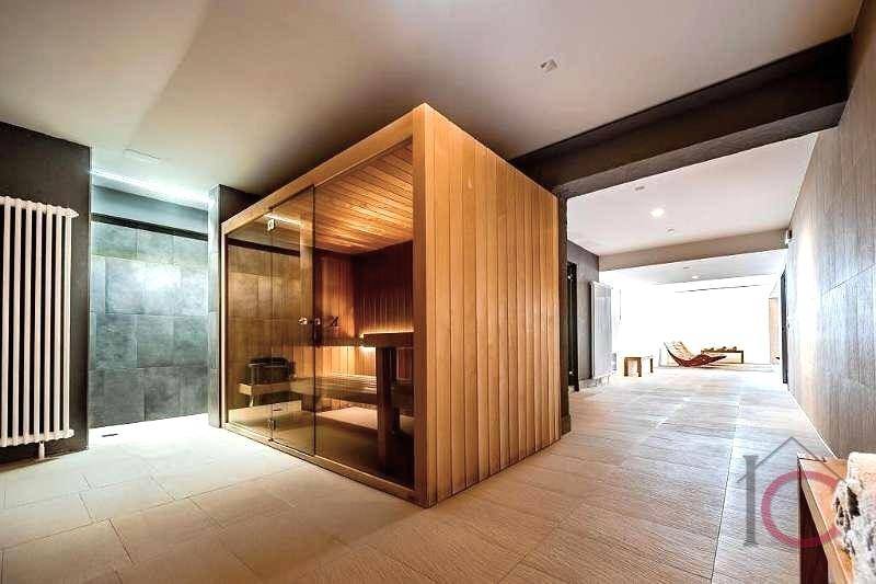 Geräumiger Wellnessbereich mit moderner Sauna und Fliesenboden für Entspannung.