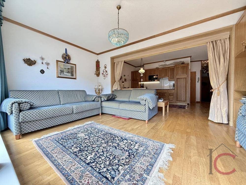 Geräumiges Wohnzimmer mit zwei Sofas und Blick auf den angrenzenden Küchenbereich, ideal zum Entspannen.