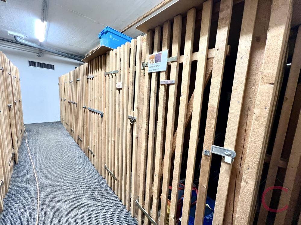 Geräumiger Abstellraum mit Holzverschlägen, bietet viel Platz für Lagerung.