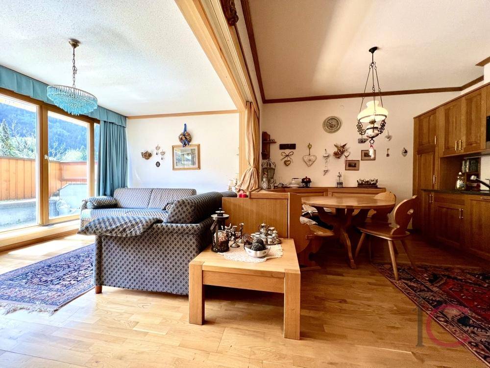 Heller Wohnbereich mit bequemen Sofas, Holzboden und weitem Blick auf die umliegende Berglandschaft.