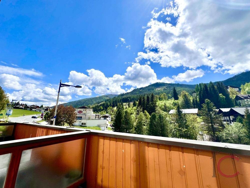 Sonniger Balkon mit weitem Blick auf die Berge und die umliegende Natur, ideal zum Entspannen.