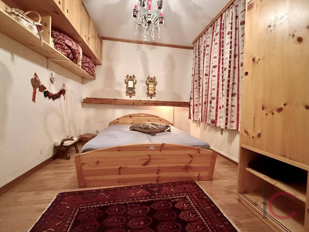 Rustikales Schlafzimmer mit Holzbett, offenen Regalen und traditioneller Dekoration, strahlt Gemütlichkeit aus.