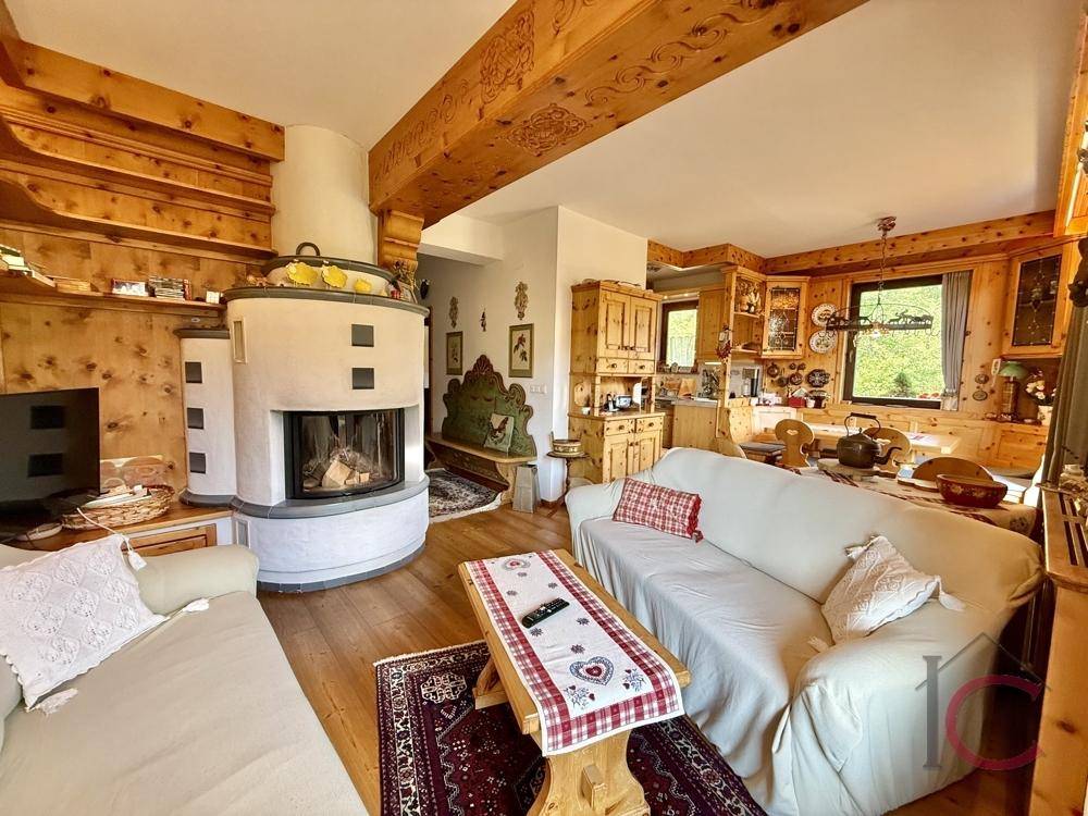 Rustikaler Wohn- und Essbereich mit Kamin, Holzbalken und traditionellen Möbeln.