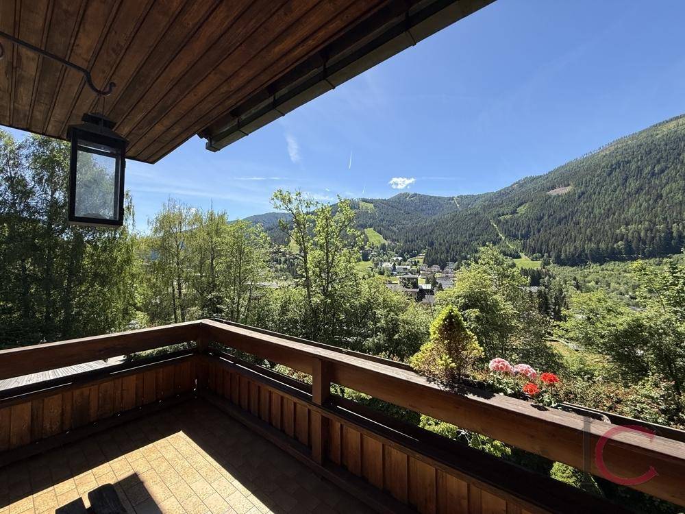 Balkon mit Holzboden und Geländer, bietet einen weiten Blick auf die Bergwelt.