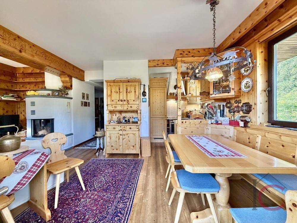 Geräumiger Wohn- und Essbereich mit Kamin, Holzbalken und traditioneller Einrichtung.