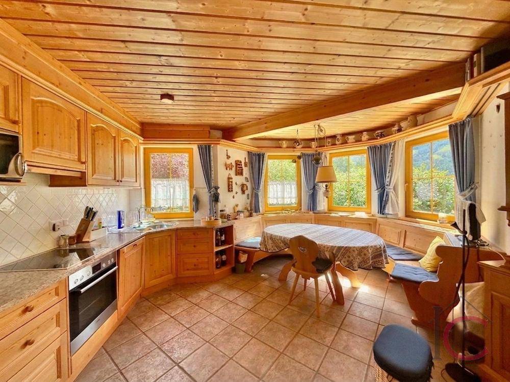 Gemütliche Holzküche im Landhausstil mit Essbereich und Fenstern mit Bergblick.