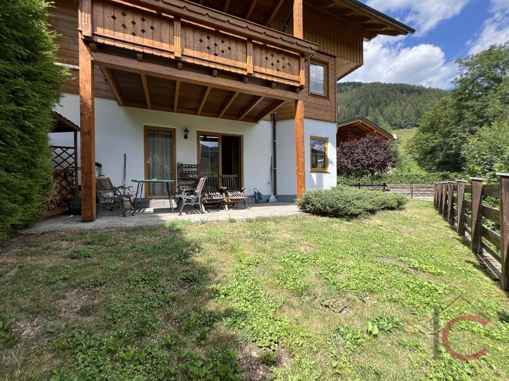 Sonniger Terrassenbereich mit Gartenmöbeln und direktem Zugang zum Garten.
