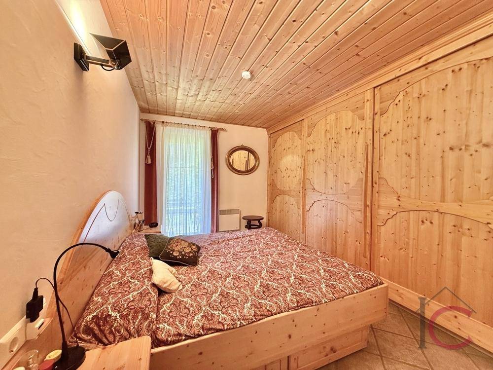 Gemütliches Schlafzimmer mit Holzbett, Einbauschränken und Holzdecke im Landhausstil.