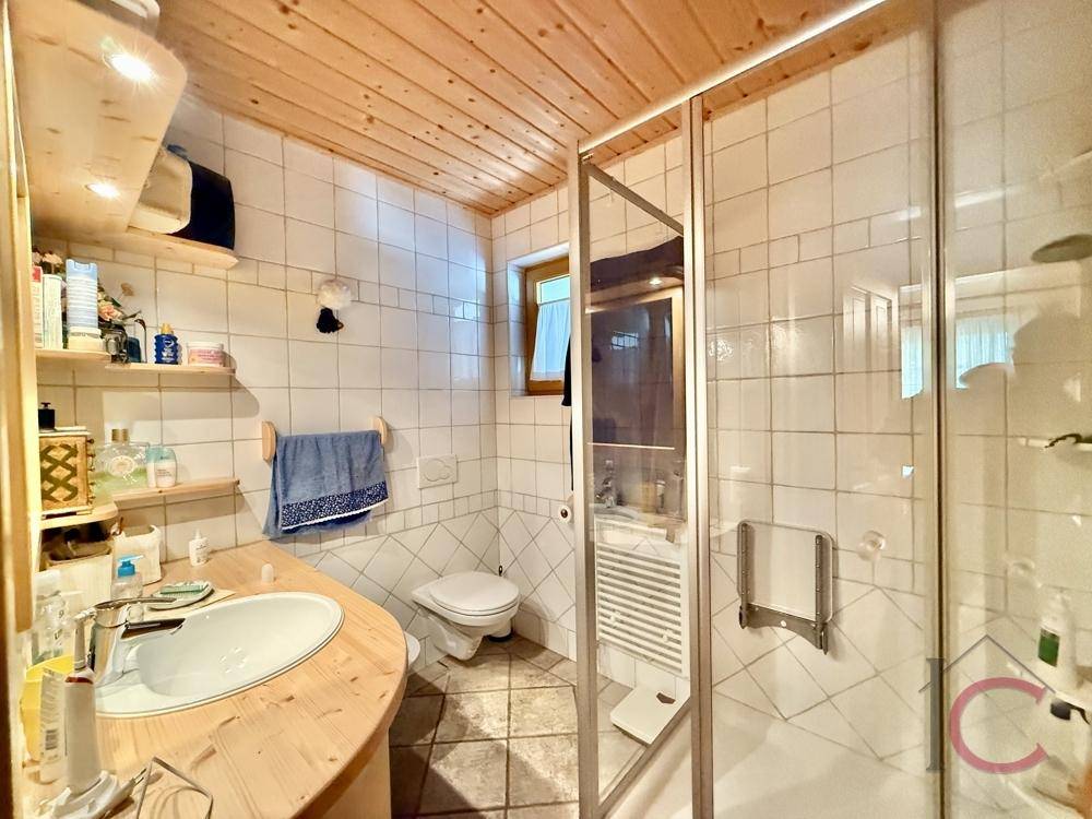 Funktionales Badezimmer mit Dusche, Waschbecken, WC und Fenster.