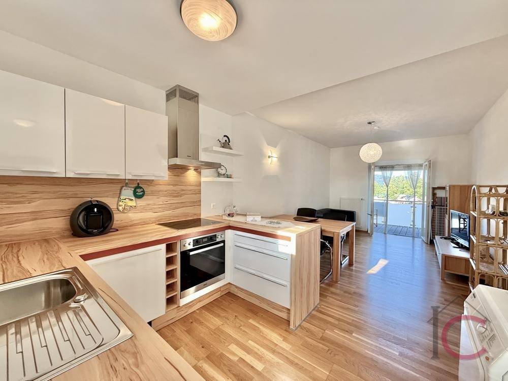 Moderne offene Küche mit Holzarbeitsplatten und Essbereich, mit Zugang zum Balkon.