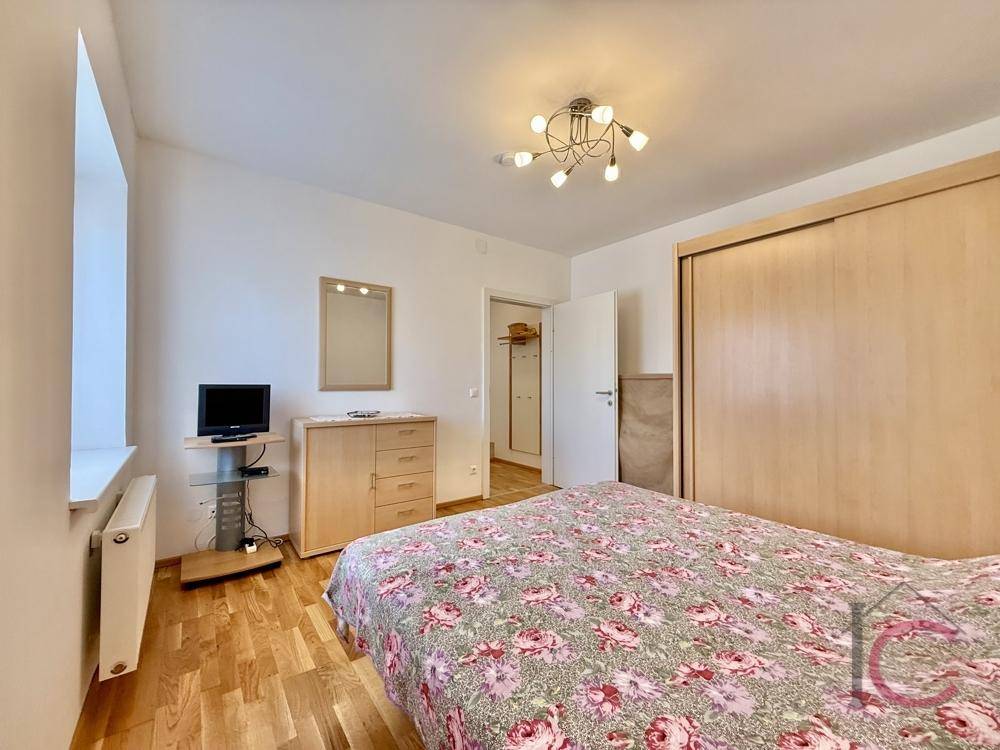 Gemütliches Schlafzimmer mit Doppelbett, Holzmöbeln und geräumigem Kleiderschrank.