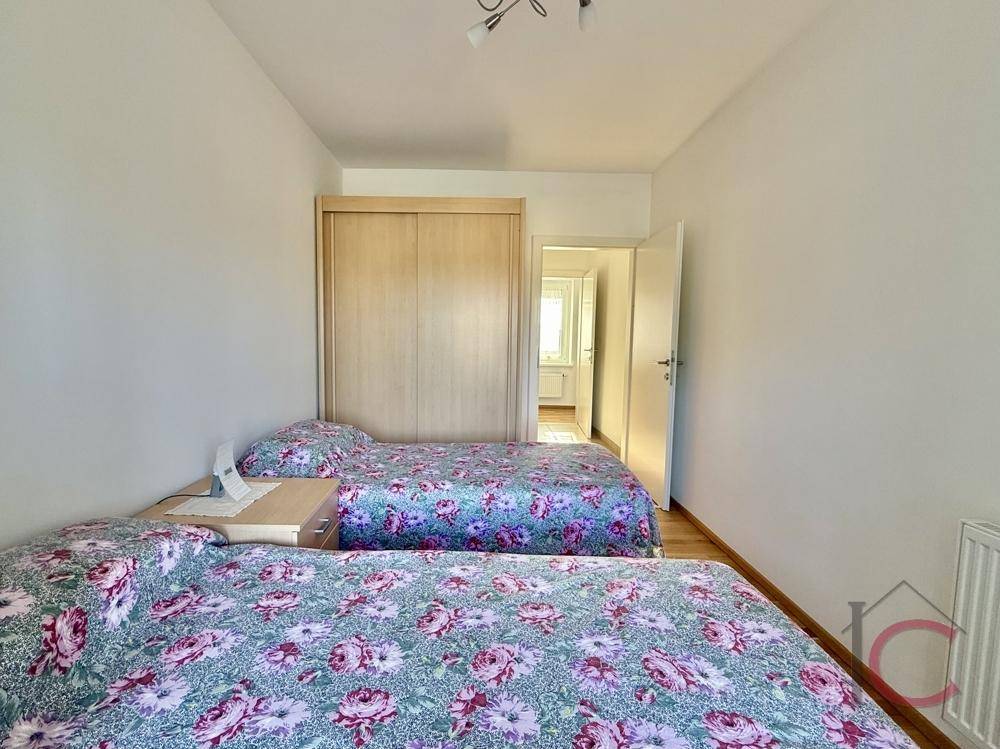 Schlafzimmer mit zwei Einzelbetten und geräumigem Einbauschrank, ideal für Gäste.