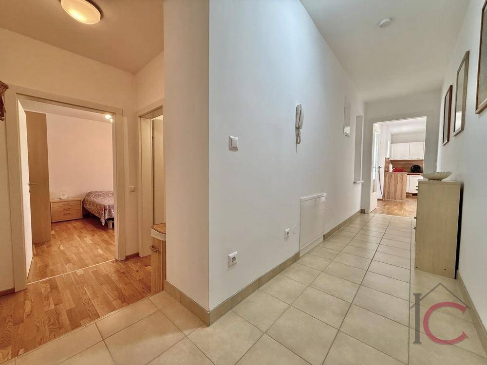 Langer, heller Flur mit Fliesenboden, der verschiedene Räume der Wohnung verbindet.