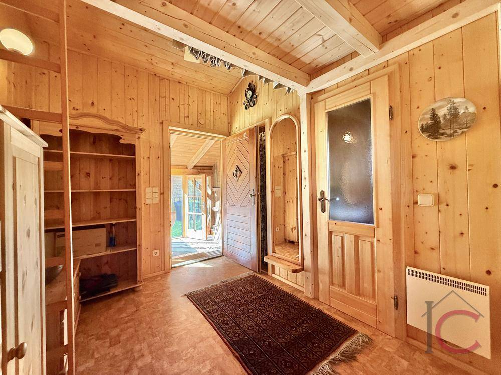 Gemütlicher Eingangsbereich mit Holzvertäfelung, Holzboden und traditionellen Möbeln.