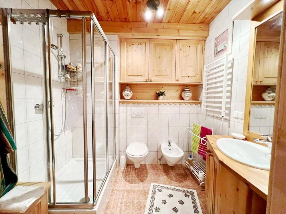 Badezimmer im Landhausstil mit Dusche, Bidet, WC und Holzwaschtisch.