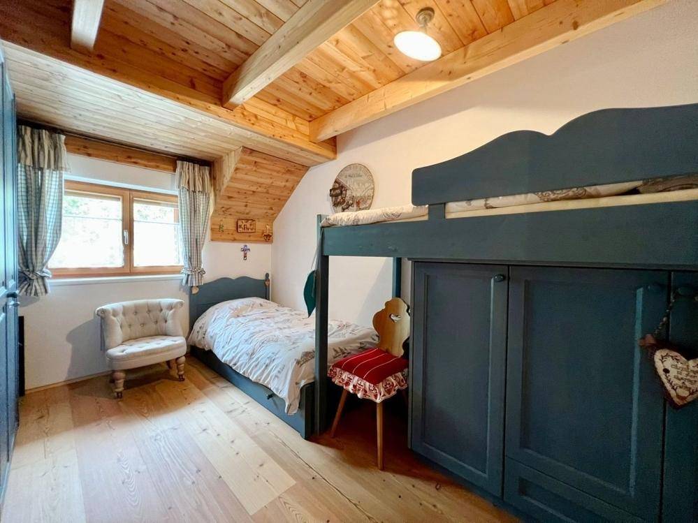 Kinderzimmer mit Etagenbett, Holzboden und Dachschräge, ideal für Familien.