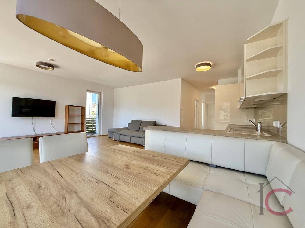 Essbereich mit Holztisch und Eckbank, angrenzend an die moderne offene Küche.