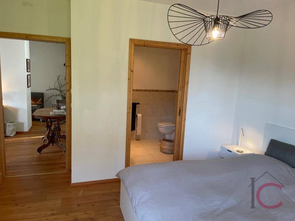 Schlafzimmer mit Blick auf das angrenzende Badezimmer durch eine offene Tür.