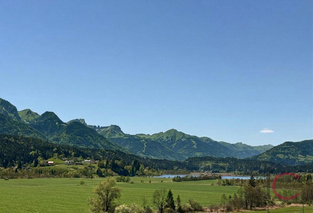 Malerischer Panoramablick auf die grüne Berglandschaft mit einem See im Tal.