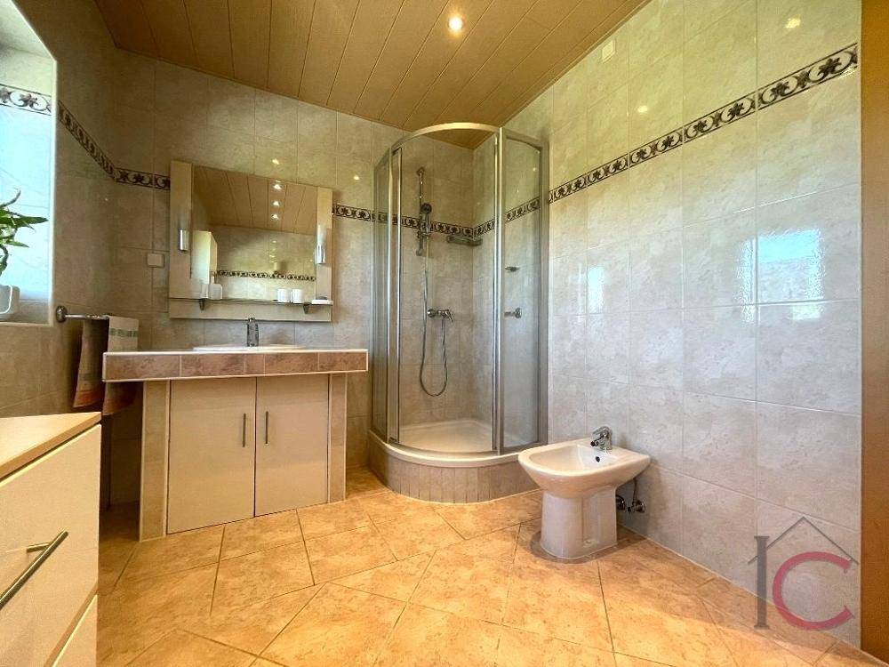 Badezimmer mit Eckdusche, Bidet und hellen Fliesen im traditionellen Stil.