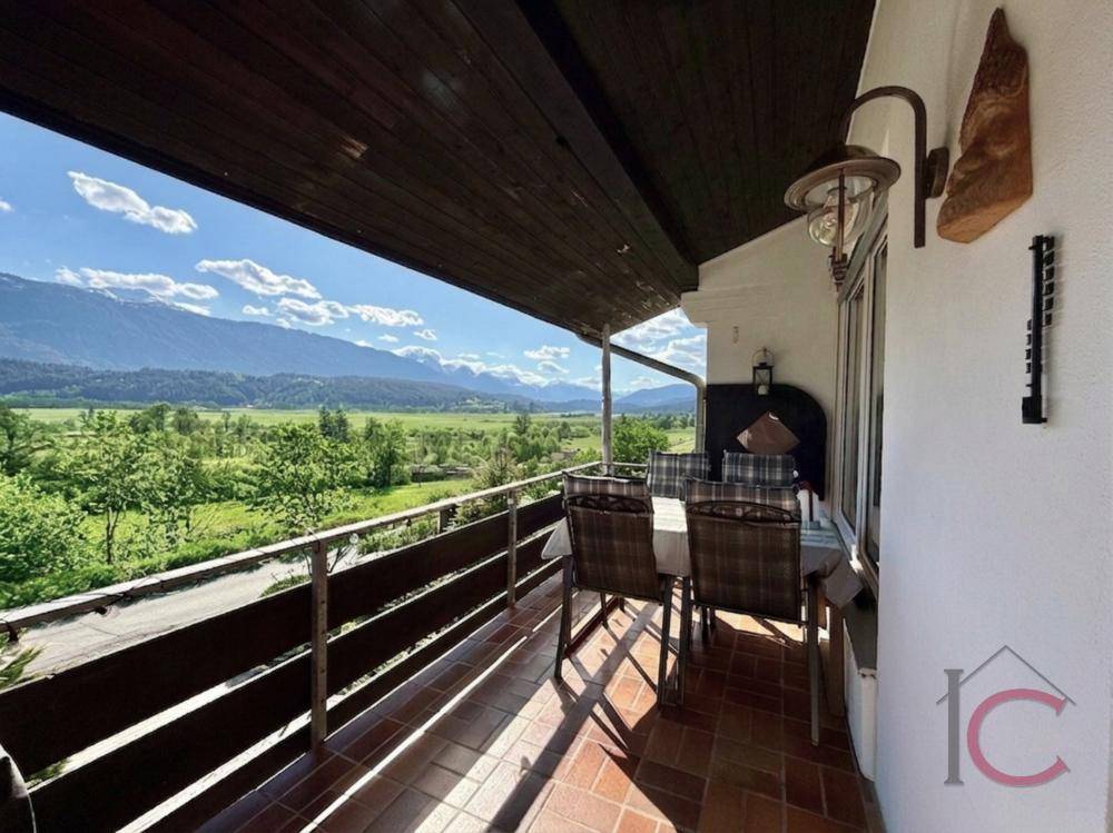 Möblierter Balkon mit Fliesenboden und atemberaubendem Panoramablick auf die Berge.