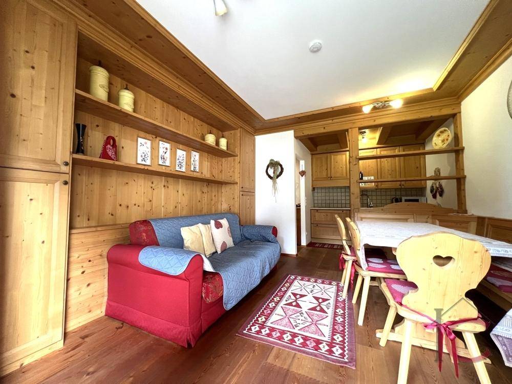 Rustikaler Wohnbereich mit Holzvertäfelung, bequemer Couch und integrierten Regalen für Dekoration.