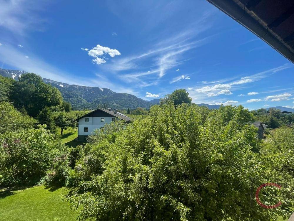 Panoramablick vom Balkon auf die grüne Landschaft und die majestätischen Berge.