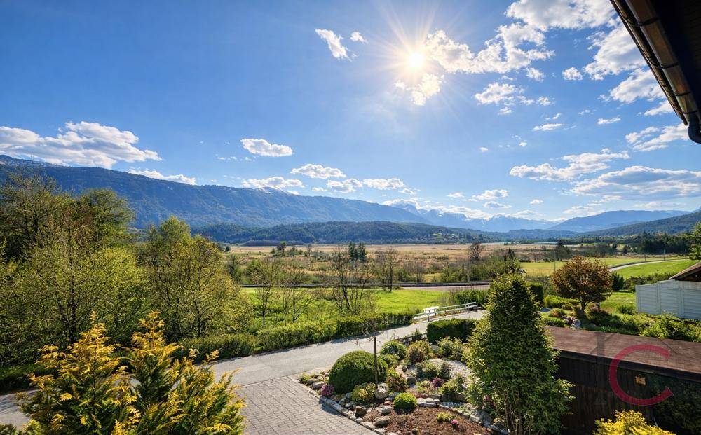 Weitläufiger Blick auf die Berge und grüne Landschaft unter strahlend blauem Himmel.