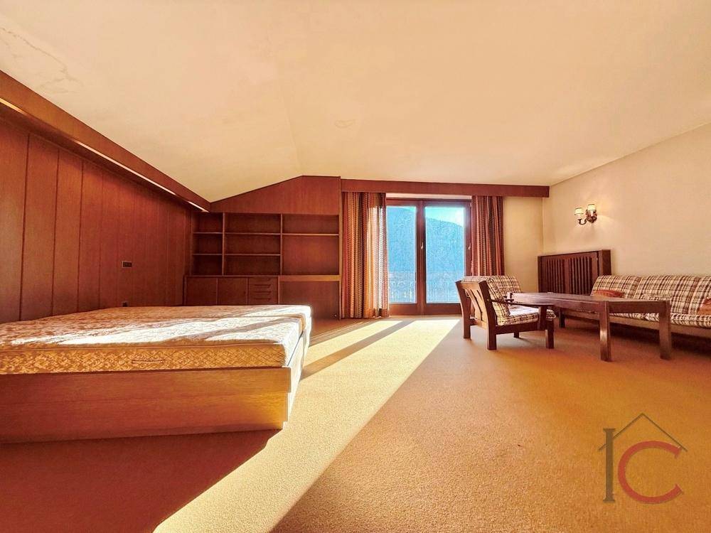 Gemütliches Schlafzimmer mit Teppichboden, Holzmöbeln und viel natürlichem Licht.