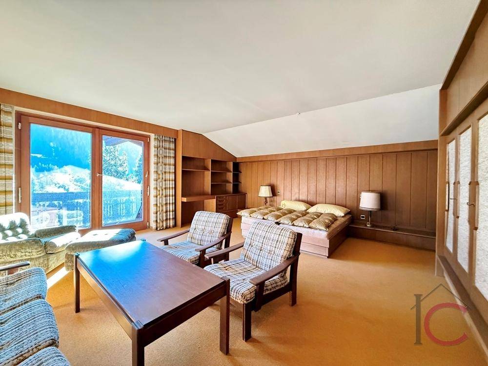 Schlafzimmer mit Teppichboden, Holzvertäfelung und großem Fenster mit Bergblick.