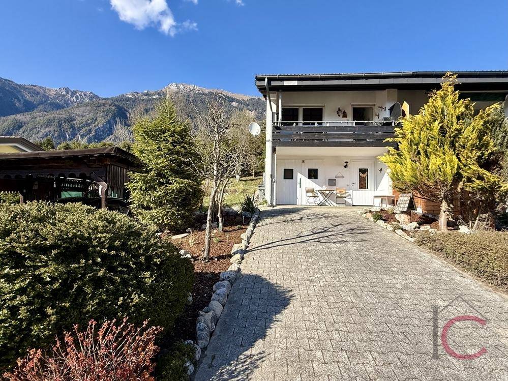 Ansicht des Hauses mit gepflasterter Auffahrt und Bergblick im Hintergrund.
