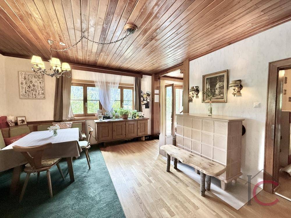 Gemütlicher Wohn-Essbereich mit Holzboden, Holzdecke und traditionellen Möbeln.