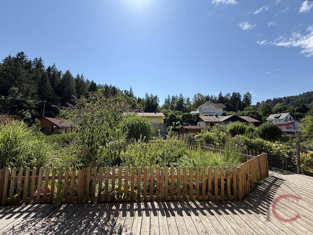 Weitläufiger Gartenbereich mit Holzdeck und idyllischem Blick auf die umliegende Hügellandschaft.