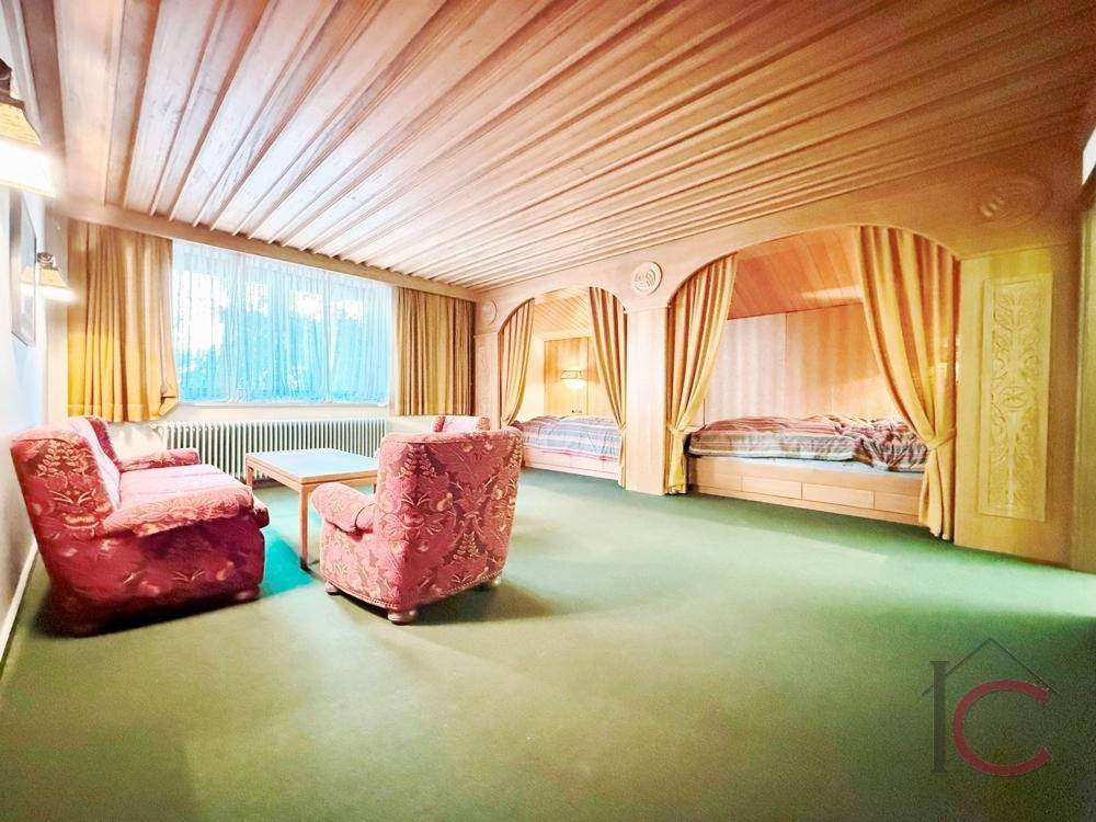 Rustikales Schlafzimmer mit Holzdecke, Teppichboden und eingebauten Alkovenbetten.