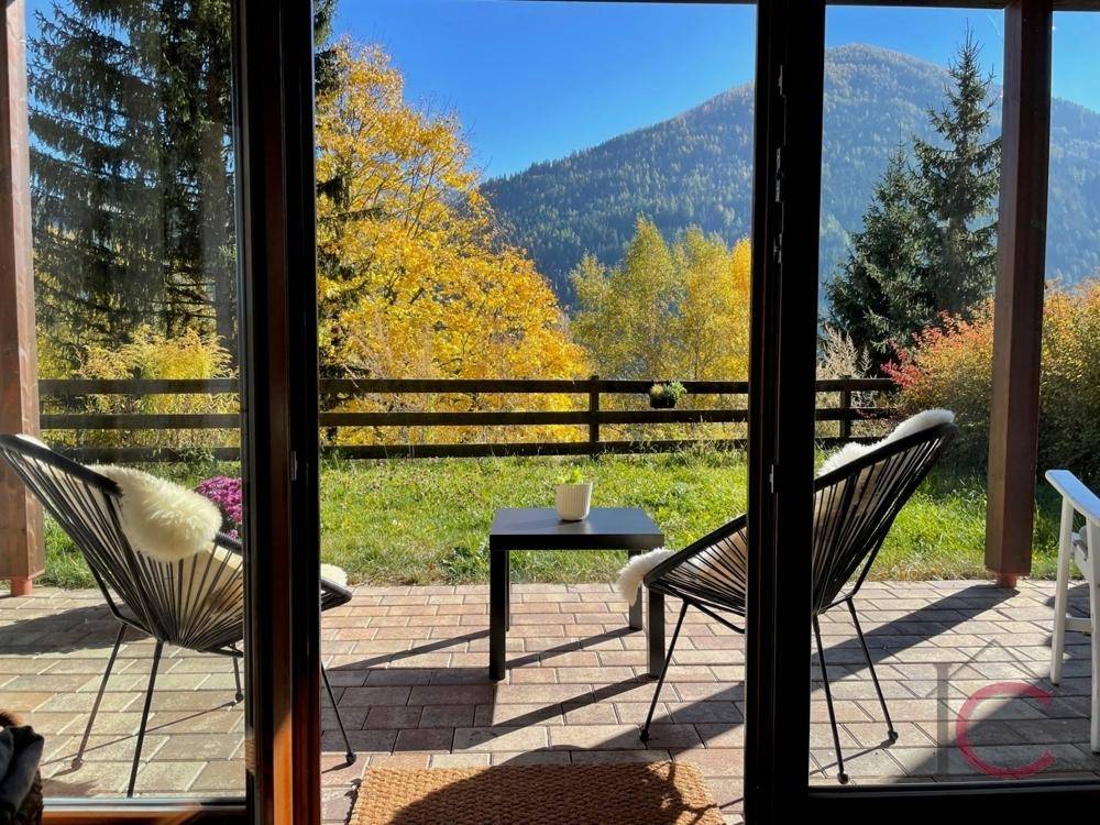 Terrasse mit Sitzgelegenheiten und herrlichem Blick auf die herbstliche Berglandschaft.