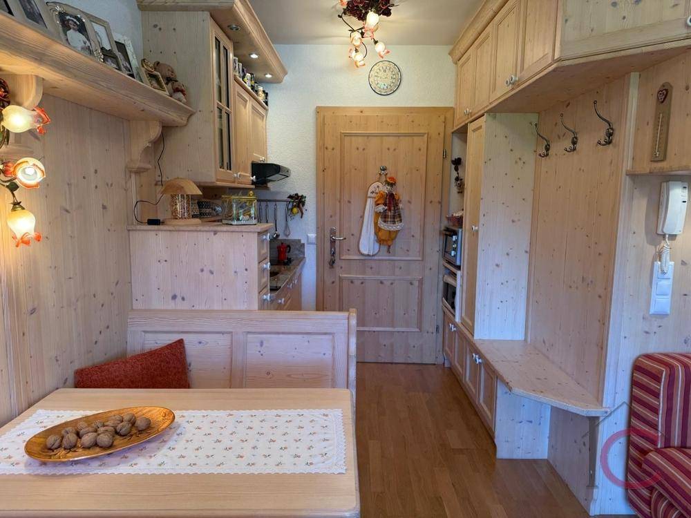 Gemütlicher Wohn-Essbereich mit Holzeinrichtung, integrierter Garderobe und traditionellem Charme.