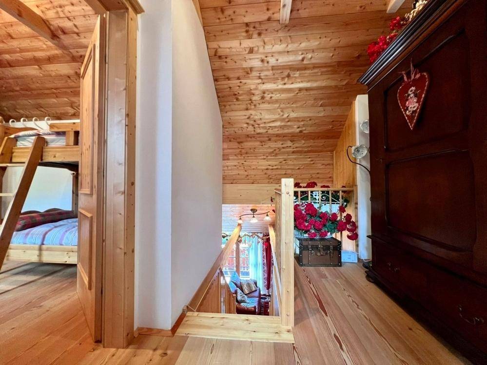 Obere Etage mit Holzboden, Dachschräge und Blick auf das untere Stockwerk.