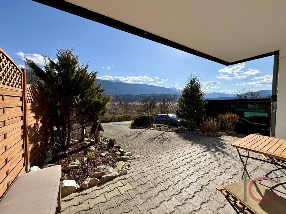 Überdachte Terrasse mit Sitzgelegenheiten und weitem Blick auf die Berge und Landschaft.
