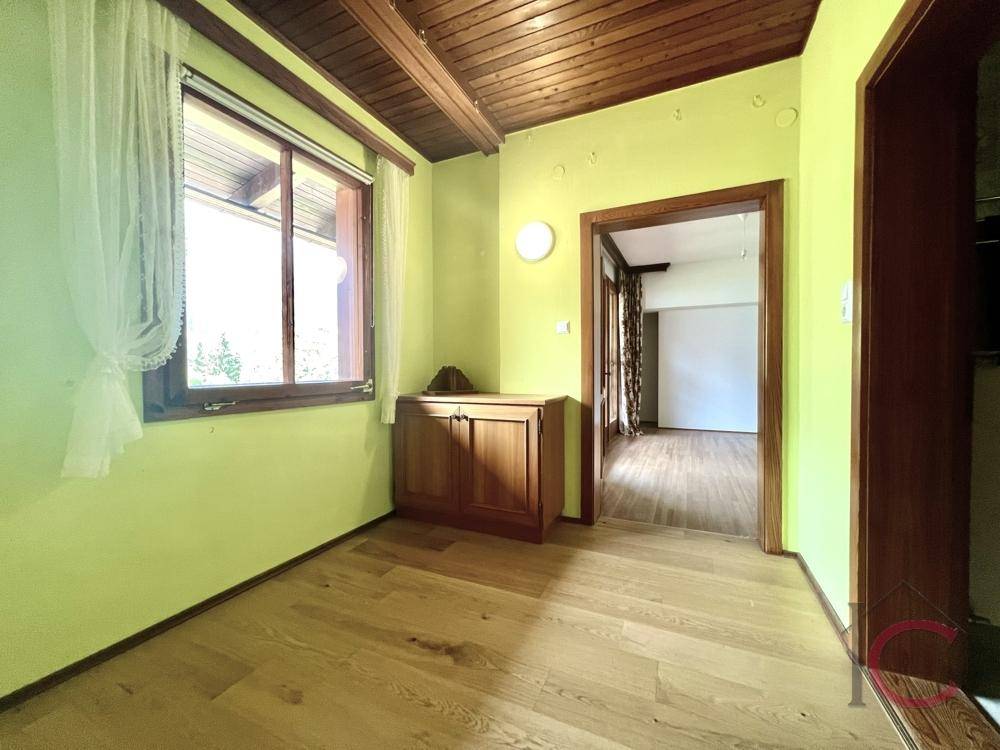 Heller Raum mit Holzboden und Fenster, ideal als Schlaf- oder Arbeitszimmer.