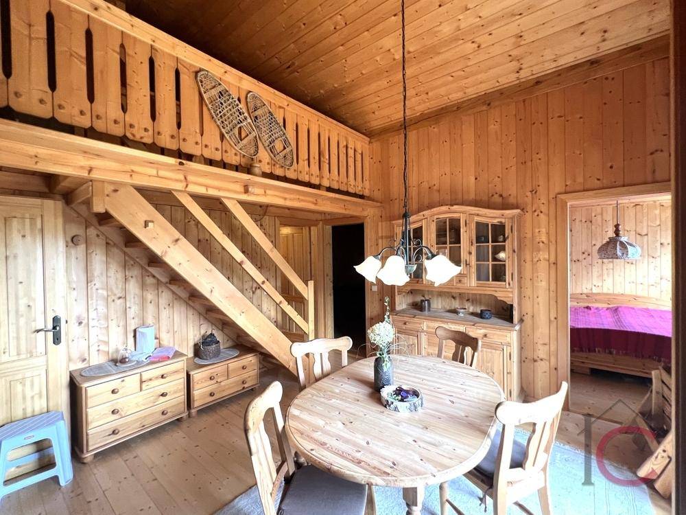 Rustikaler Essbereich mit Holzmöbeln, Treppe zum Loft und traditioneller alpiner Einrichtung.