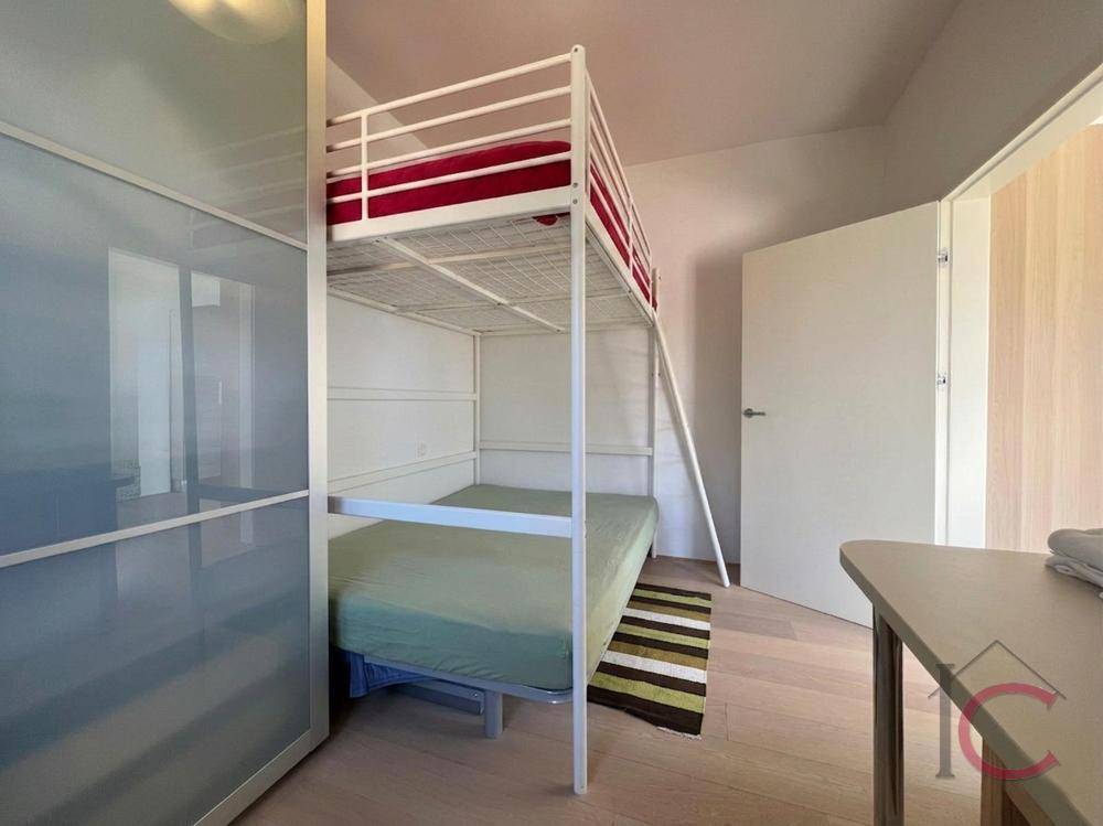 Kinderzimmer mit Etagenbett und integriertem Kleiderschrank, hell und funktional eingerichtet.
